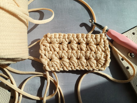 The process of crocheting a handbag made of cord and leather accessories. High quality photo