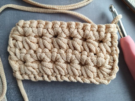 The process of crocheting a handbag made of cord and leather accessories. High quality photo