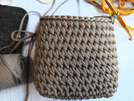 The process of crocheting a handbag made of cord and leather accessories. High quality photo