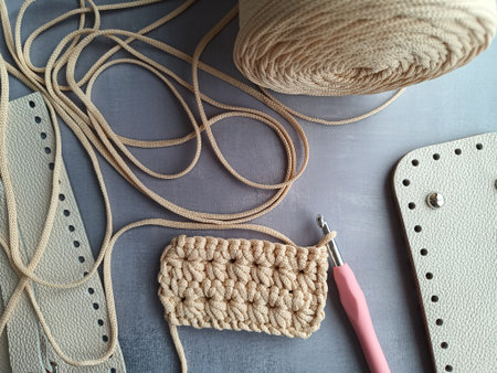 The process of crocheting a handbag made of cord and leather accessories. High quality photo