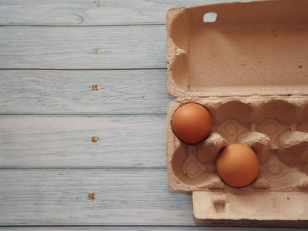 chicken eggs in an egg box on wooden background. High quality photoの写真素材