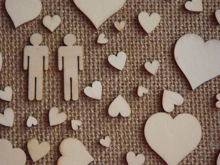 wooden hearts of different sizes and figurines of a man and a woman on jute fabric as a Valentine's day card. Declaration of love. High quality photoの写真素材