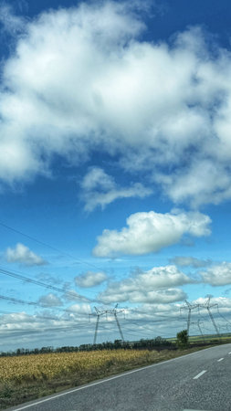Country road with blue sky and white clouds. View from the car.の写真素材