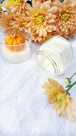 Cosmetic cream with pumpkins in a glass jar on a white backgroundの写真素材