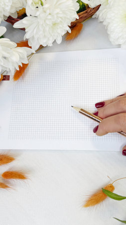 Woman writing in a notebook with a fountain pen on a white backgroundの写真素材