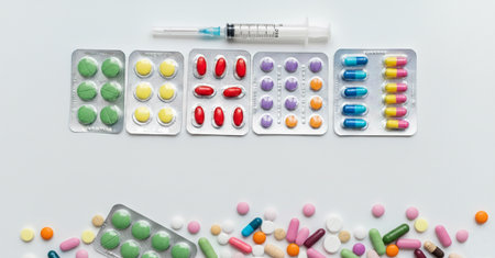 Pills and syringe on a white background, top view.の素材