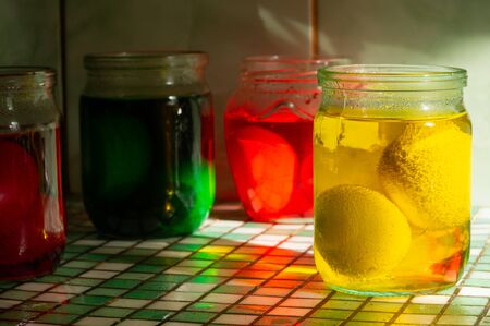 Homemade traditional Easter eggs coloring in glass jars with different organic paints close-up no peopleの写真素材