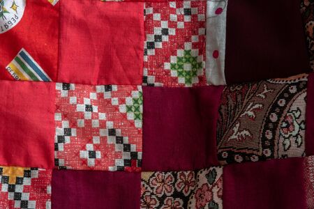 Red patchwork quilt fragment, Colorful handmade ethnic blanket.の写真素材