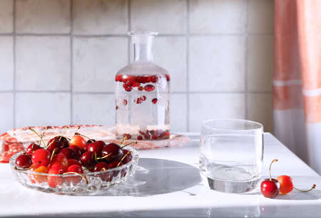 A dish of ripe cherries and soft drinks in glass utensils. Still-life.の写真素材