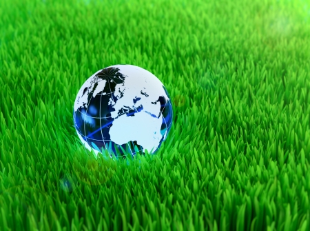 Blue crystal globe on grass symbol of environmental conservationの写真素材