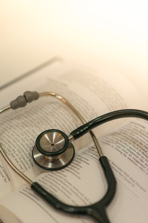 Medical concept with medical stethoscope and textbook selective focus