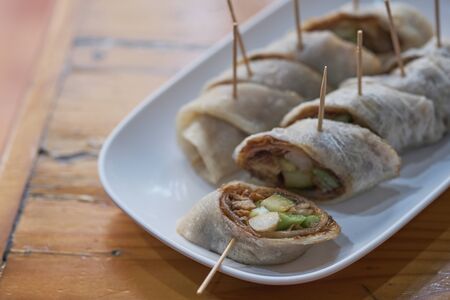 Plate with fresh spring rolls in rice paper on table selective focusの写真素材