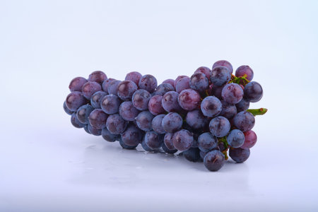 Kyoho grapes (giant mountain grapes) , with some grapes scattered out in front. Isolated on white.の写真素材