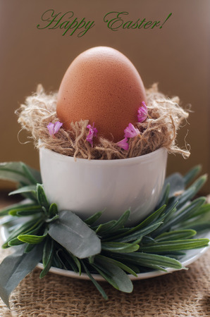 Close up of Easter egg with nest and flowers on sacking background. Happy Ester concept.の写真素材