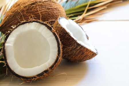 Close up of coconut with palm leaf on wooden background. Copy space.の写真素材