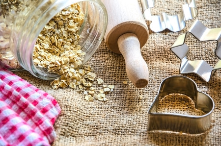 Porridge oats in the jar with   rolling pin and baking moldsの写真素材