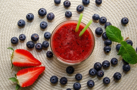 Strawberry and blueberry smoothie on beige  background. 