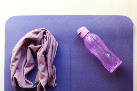 Water bottle, sport towel on lilac mat.Concept for yoga, pilates or fitness.の写真素材