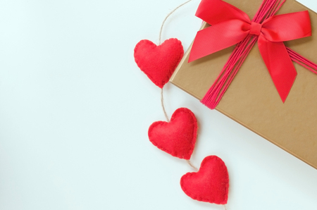 Gift gold box with red bow and red hearts on white background. Concept for Love or Saint Valentine Day. Vintage style. Copy spaceの写真素材