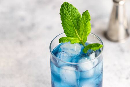Blue lagoon, Tropical cocktail served with ice cubes decorated with mint. Refreshing alcohol drink for party at summer.の写真素材