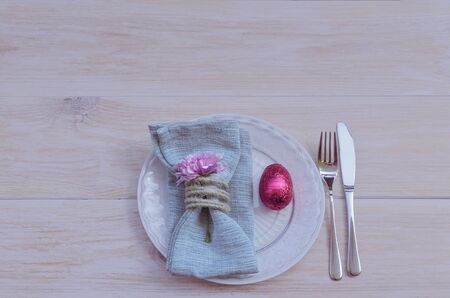 Top view of beautiful spring table settings en blue tone, silver cutlery, rustic napkin ring with...