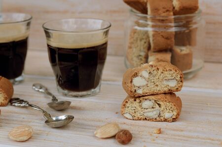 Fresh baked biscotti cantuccini, Italian almond sweets biscuits with glass of espresso coffee on woodem table. Italian cookies cantucci background.の写真素材