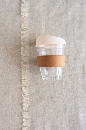 Reusable glass Coffee cup on natural linen background. Reuse, reduce, recycle and no plastic...