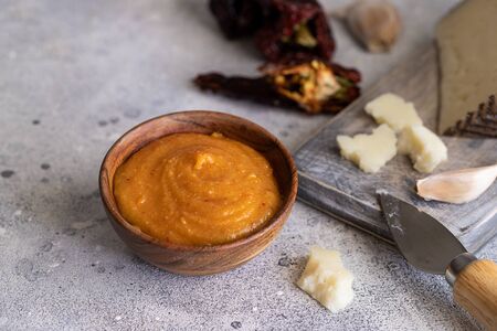Famous La Gomera paste or sauce Almogrote in wooden bowl with ingredients hard goat cheese, peppers, olive oil and garlic on light concrete background.の写真素材
