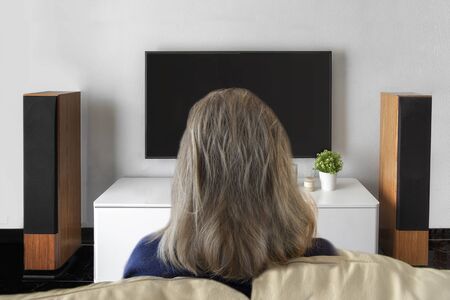 Unrecognised woman watching television at home. Smart tv and home cinema conceptの写真素材