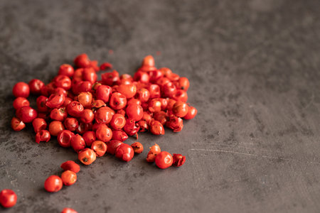 Pink peppercorns on black lbackground. Copy space