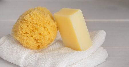 Natural sea sponge with eco sopa bar  on white organic cotton towel  Eco sustainable cleaning and Zero waste concept.Large backgroud for banner.Copy spaceの写真素材