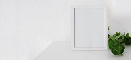 White square frame mockup with green eucalyptus plant  a white table.Large image for banner with...