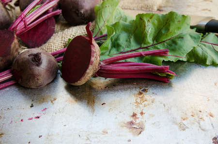 Fresh beet cut half on vintage metal background with sacking and knife.