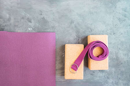 Open yoga mat, two cork blocks and yoga belt on gray cement background. Start yoga practice concept. Copy space.の写真素材