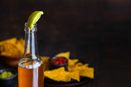 Mexican beer or bear with lime juice and Mexican snack nachos with guacamole. National food background.Copy spaceの写真素材