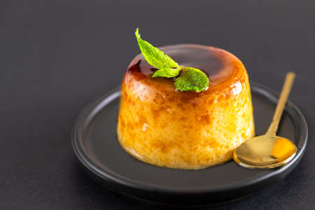 Creme caramel dessert or flan decorated with mint on black background.Restourant menu image. Copy space.の写真素材