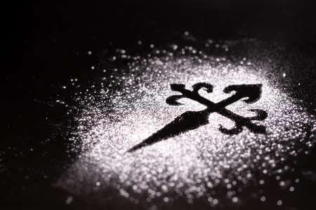 Silhouette cross made with sugar as a simbol of Tarta de Santiago (St. James cake) famous spanish almond cakeの写真素材