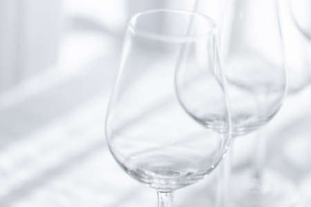 Empty glasses of wine on the white tablecloth. Abstract background.