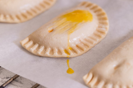 Close up of empanadilla small spanish pies on baked paper. Cooking process background.の写真素材