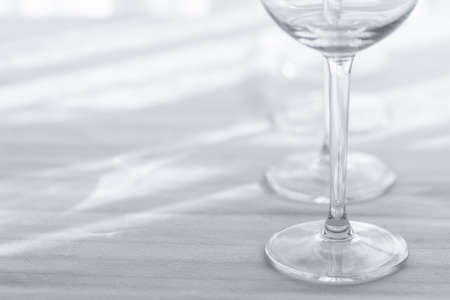 Several empty wine glasses in white gray shades on the white tableclothの写真素材