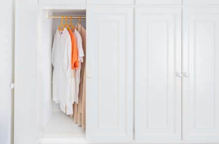White wardrobe with collection of clothes hanging on in dressing room.Modern dressing room background.の写真素材