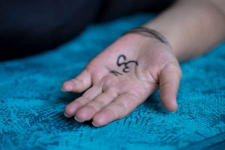 Close up of female hand with painting Om symbol on the yoga mat. Yoga concept background.の写真素材