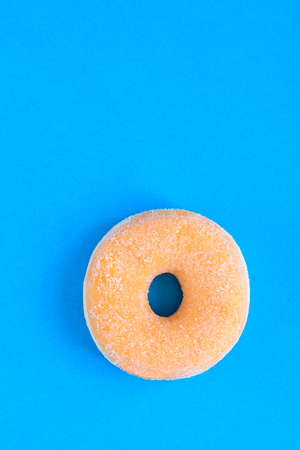Close up of classic donut with sugar on blue modern background. copy-spaceの写真素材
