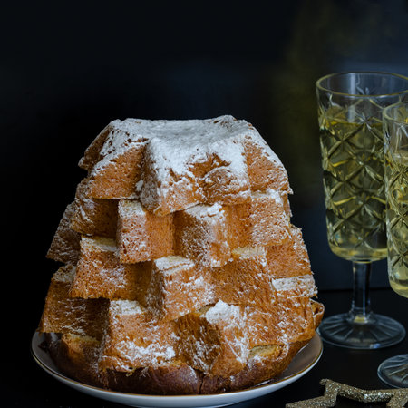 Close up of Pandoro, Italian Christmas cake with christmas decoration and champagne at the black background. Beautiful Xmas food concept.の写真素材