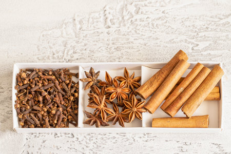 Different spices cinnamon, cloves, star anise on white background. Traditional Christmas smell and...