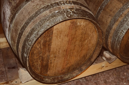 Oak barrels of wine in vineyard. Wine barrels stacked in the old cellar at the winery. Winemaking background.の写真素材