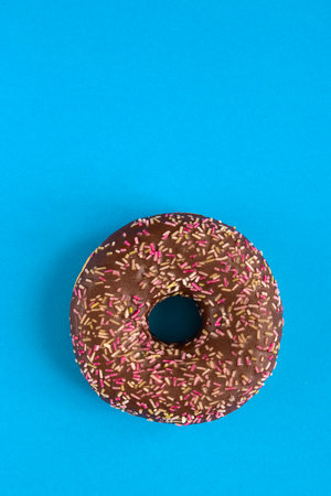 Close up of donut with sprinkle on blue modern background. copy-spaceの写真素材