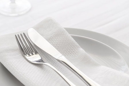 Fork and knife on a white napkin on a white backgroundの写真素材