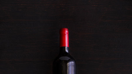 Red wine bottle on wooden table. Large background for bannerの写真素材