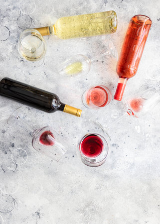 Flat-lay of red, rose and white wine in glasses and bottles over gray concrete background. Wine tasting conceptの写真素材